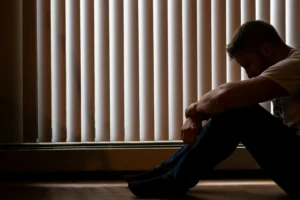 Affordable Counselling Network - Online Therapy UK - Man sitting on the floor looking low