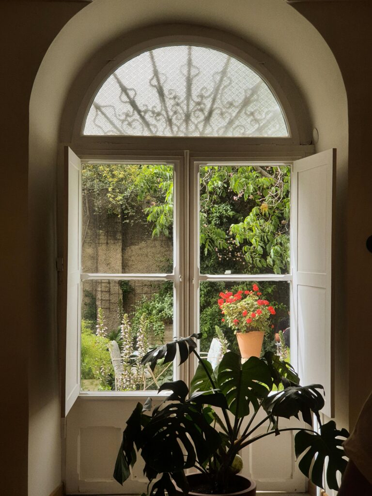 Large oval window looking over a garden.