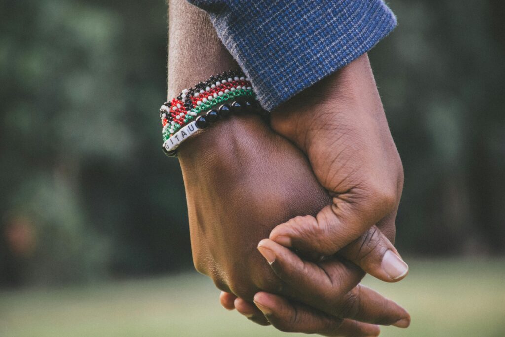 close up picture of two people holding hands. 